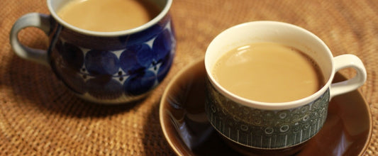 Two cups of masala chai tea with milk.
