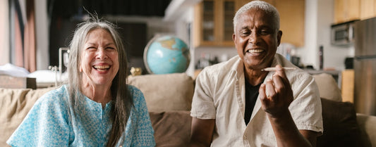 Two people sitting on a sofa smoking a joint.