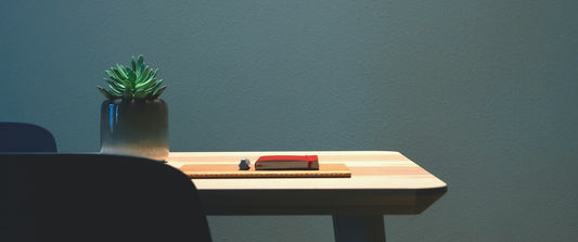 A desk with a plant and book on it.