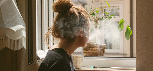 A person in Germany smoking cannabis near an open window.