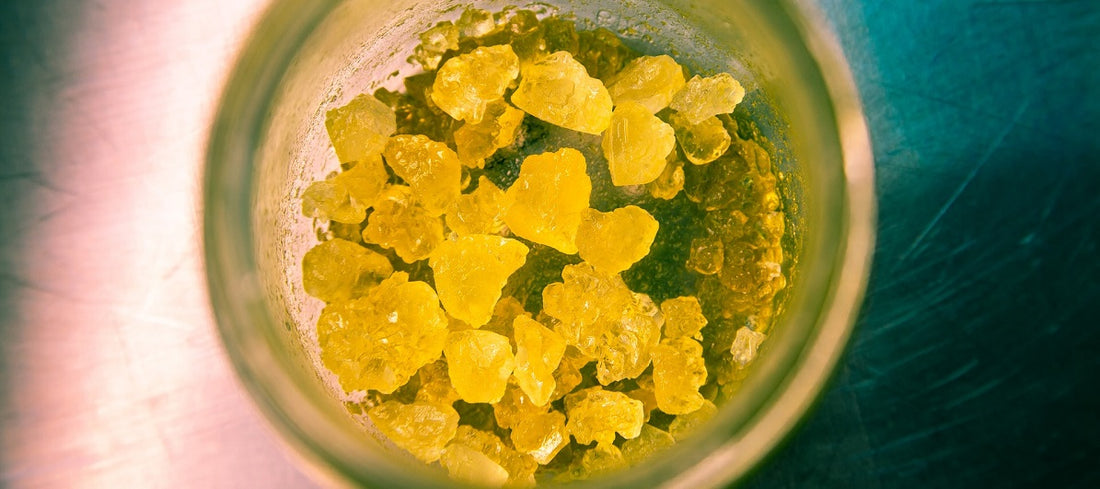 Close-up of amber colored cannabis concentrate in a jar.