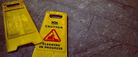 A sign saying "Caution: Cleaning in Progress" on a hard floor.