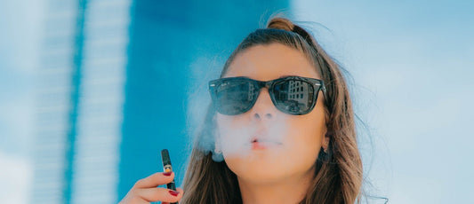 A person vaping a portable 510 oil cartridge vape pen.